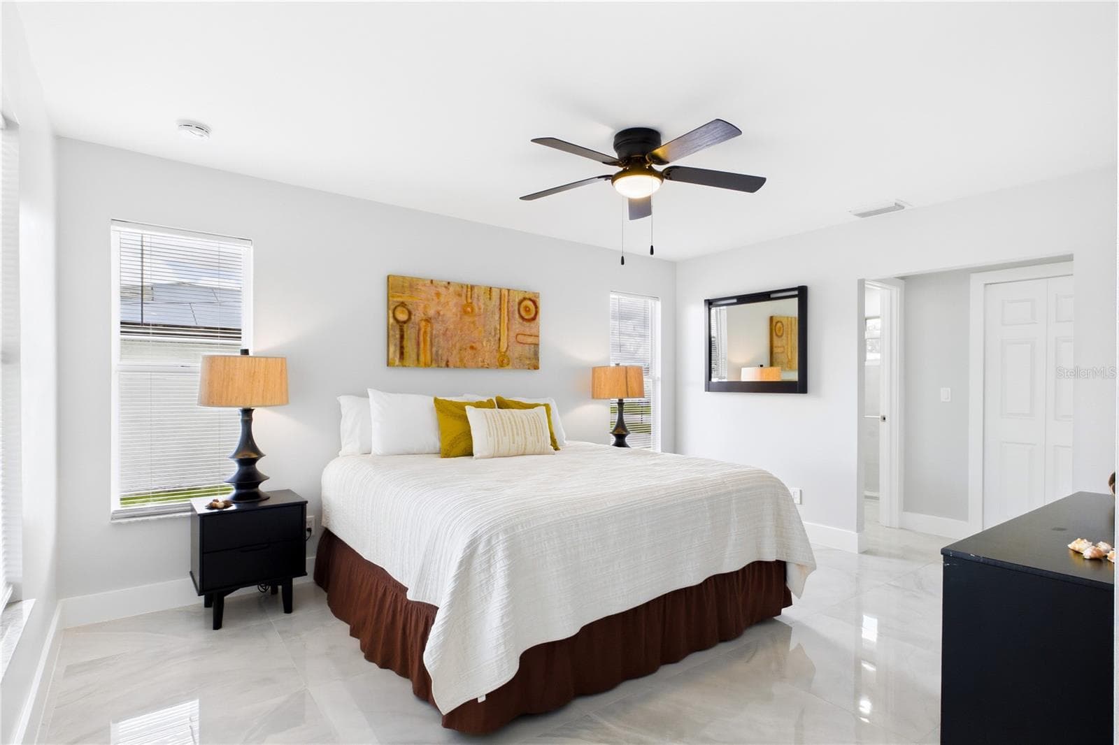 Spacious PRIMARY SUITE offers multiple windows, porcelain flooring, ceiling fan & WALK-IN CLOSET. - 256 SE SANTA BARBARA PL, CAPE CORAL