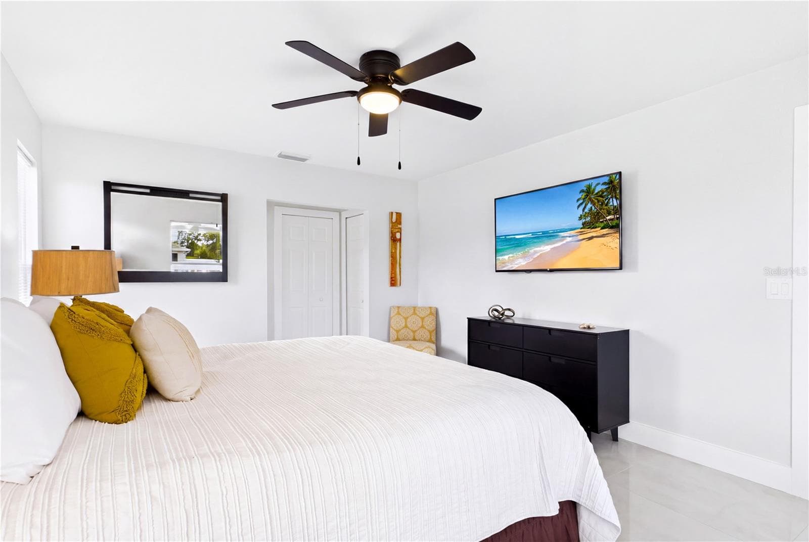 Spacious PRIMARY BEDROOM offers a bright, relaxing retreat w/ polished marble-look porcelain flooring, contemporary ceiling fan & abundant natural light. - 256 SE SANTA BARBARA PL, CAPE CORAL