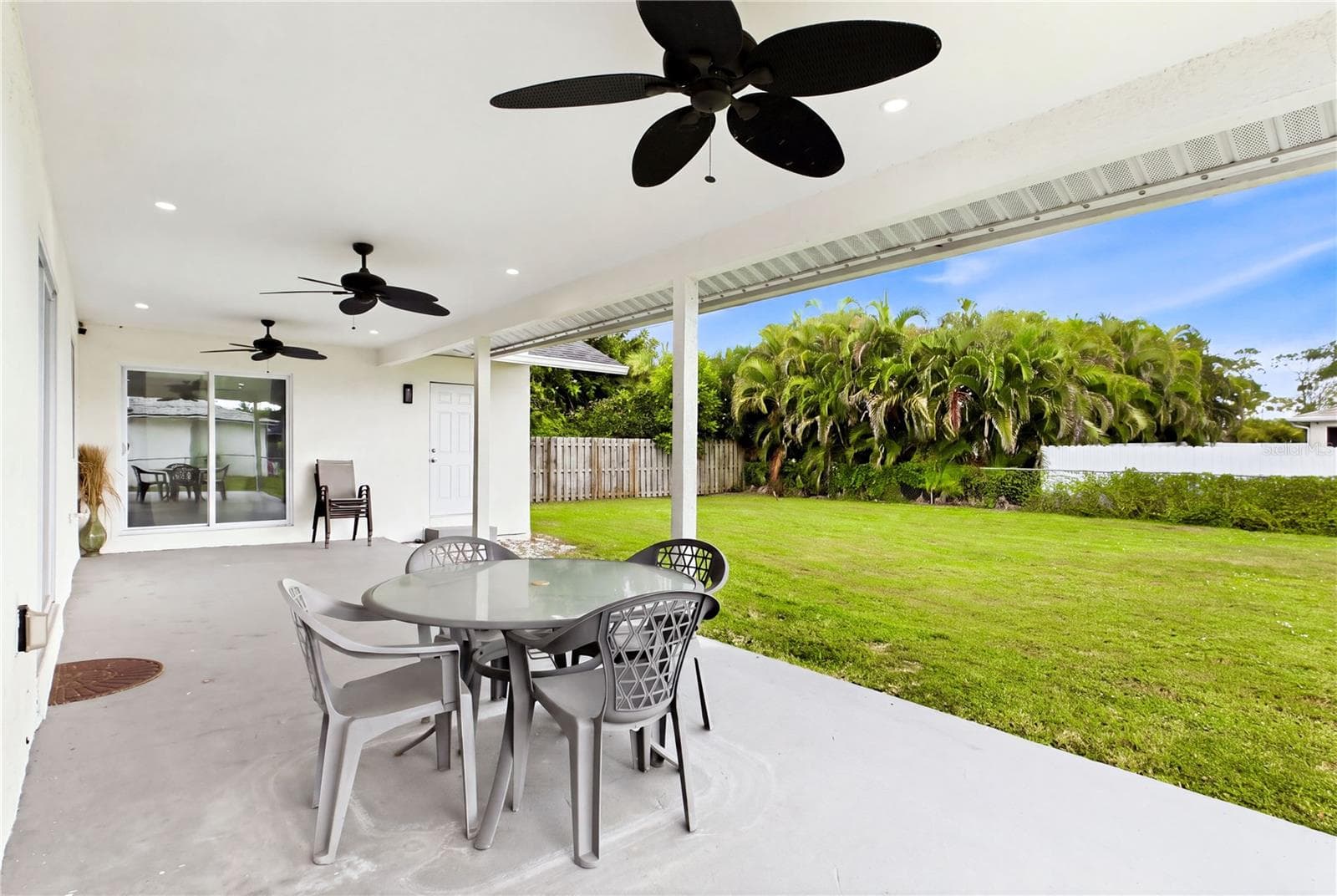 An EXPANSIVE COVERED PATIO extends the home's living space outdoors, creating the perfect setting for morning coffee, grilling, entertaining & relaxing year-round. - 256 SE SANTA BARBARA PL, CAPE CORAL