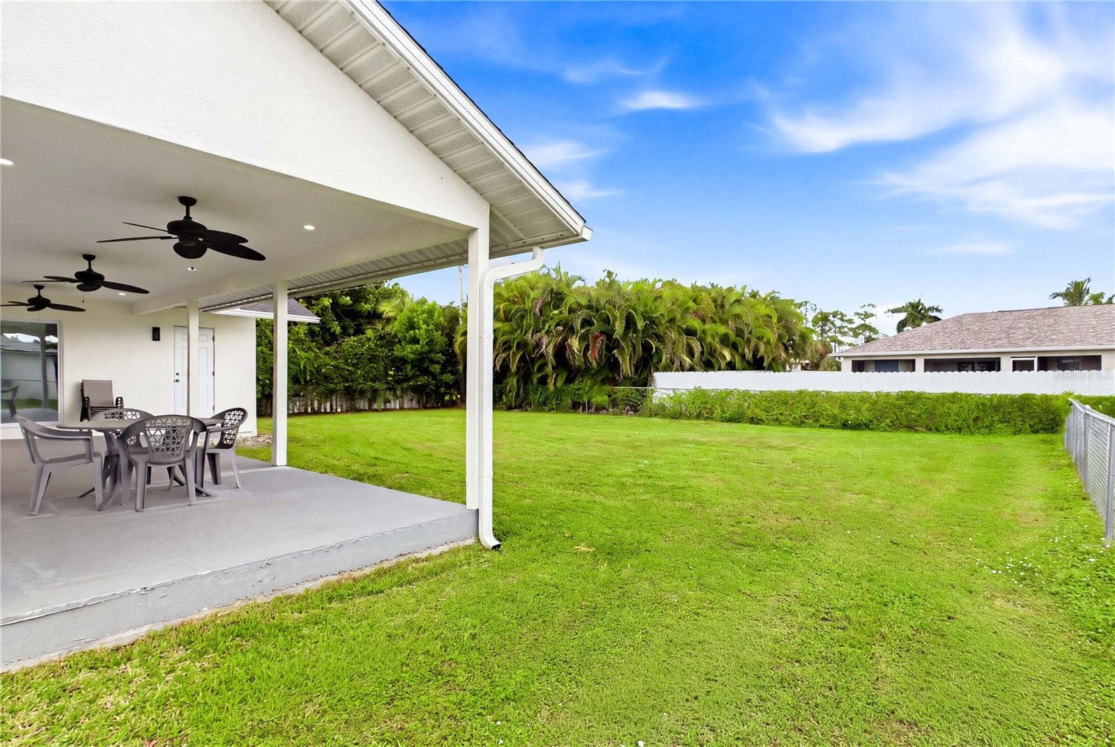 Multiple ceiling fans enhance the covered outdoor area while overlooking the spacious yard & tropical Florida setting. - 256 SE SANTA BARBARA PL, CAPE CORAL