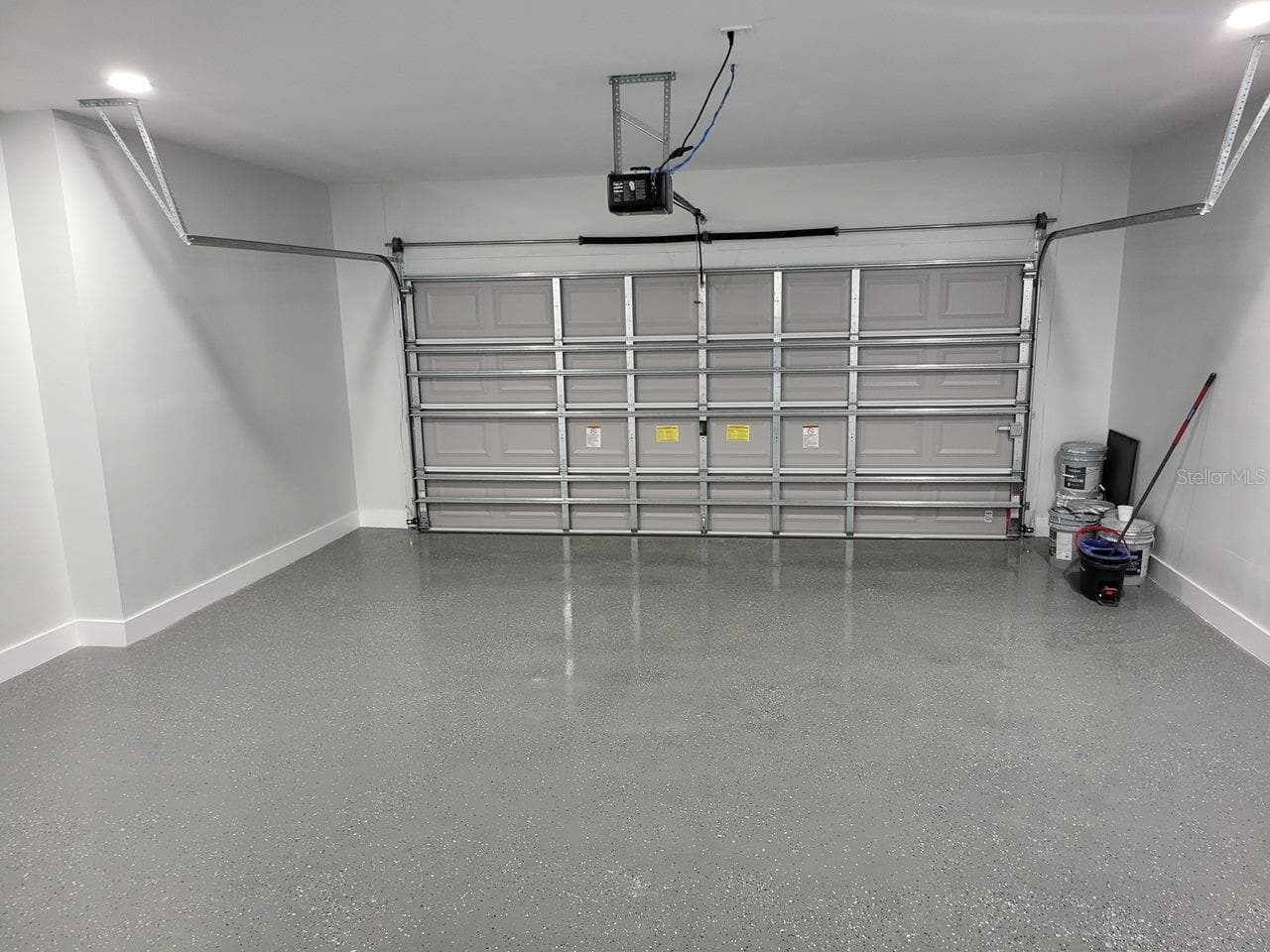 Spacious 2-CAR GARAGE features durable EPOXY FLOORING, bright finished walls & upgraded lighting for a clean, polished & functional space. - 256 SE SANTA BARBARA PL, CAPE CORAL