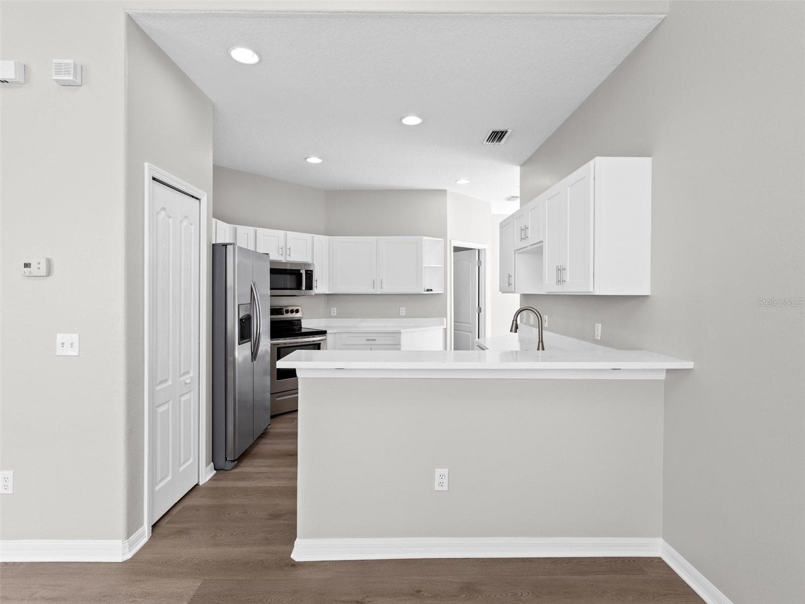 Kitchen with breakfast bar open to living room and dining room - 17912 HAVENVIEW LN, LUTZ