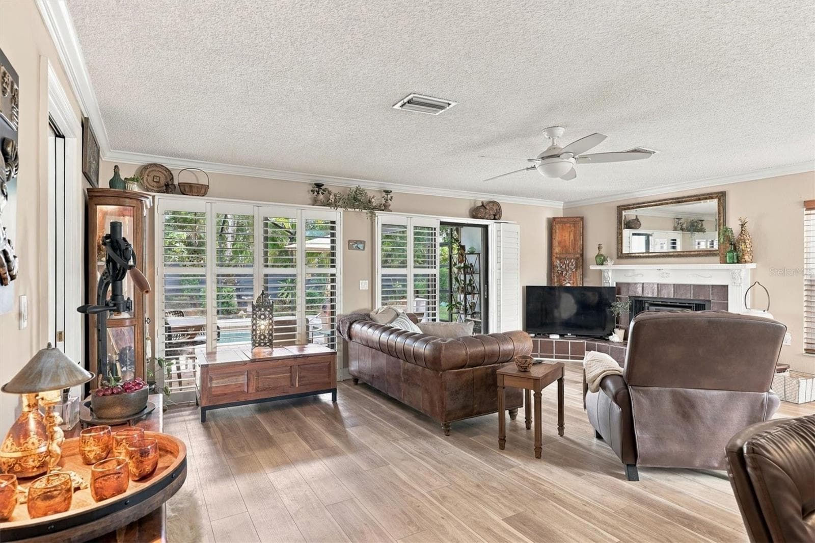 Great room with Luxury vinyl floors, Fireplace , Plantation Shutters on Sliding glass doors to the covered Lanai - 3828 EASTON ST, SARASOTA