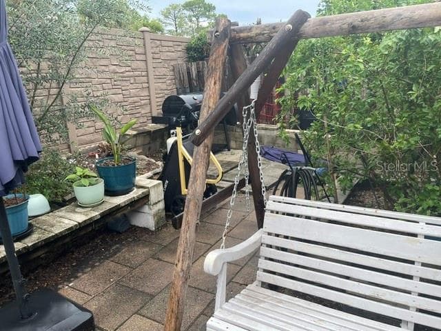 Cherry tree behind swing and olive tree,  against back fence, grape vines aslo - 2250 SPRINGWOOD CIR W, CLEARWATER
