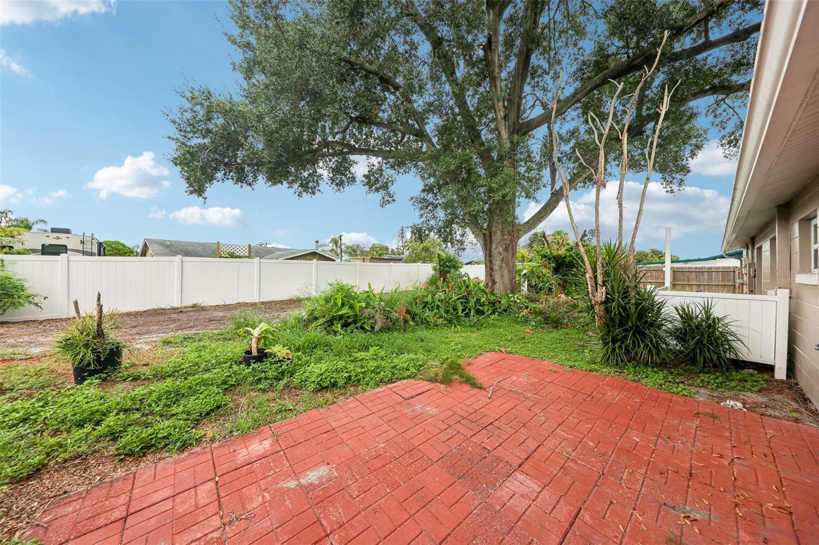 Patio overlooks a fenced backyard. - 6698 RIVO ALTO AVE, ORLANDO