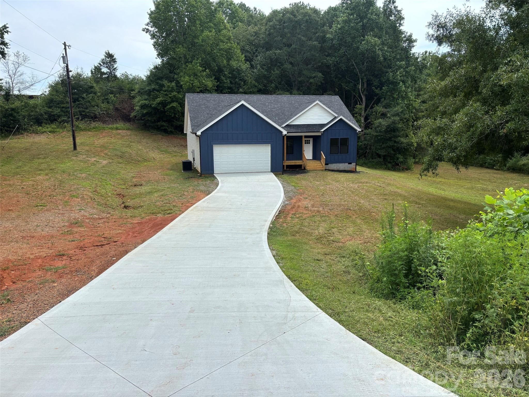 Street view with custom 6 inch deep concrete driveway - 914 Old Hollis Road, Ellenboro