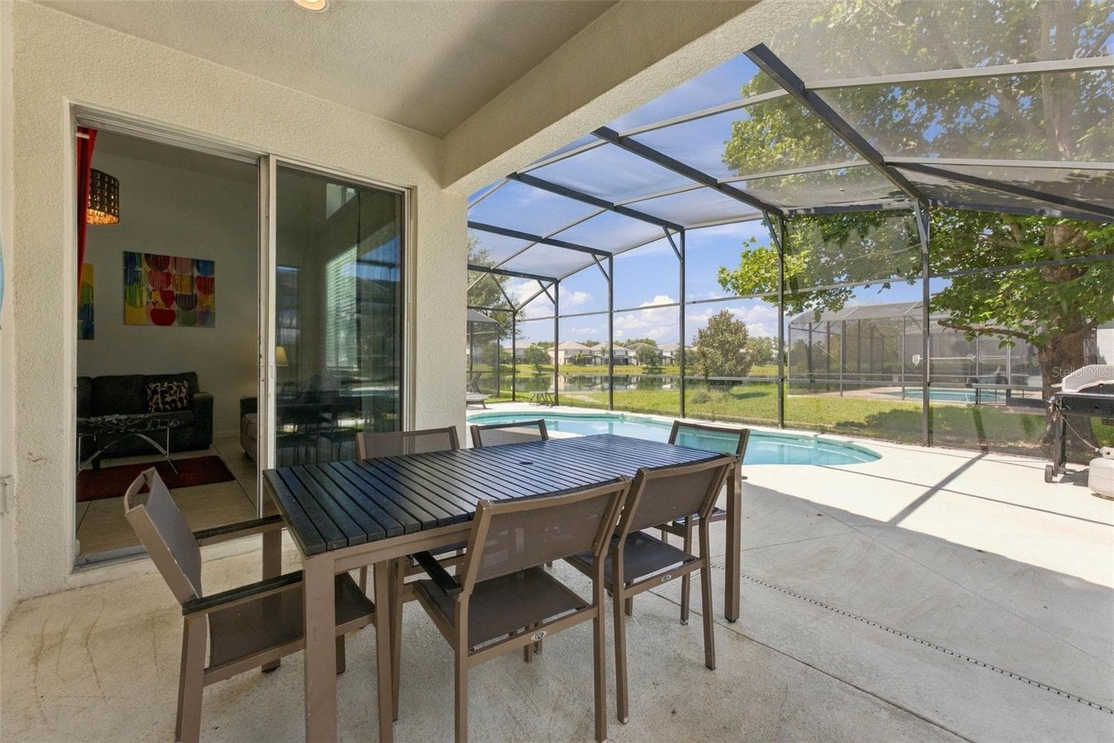 Covered patio overlooking the screened-in sparkling pool and pond. - 337 MARCELLO BLVD, KISSIMMEE
