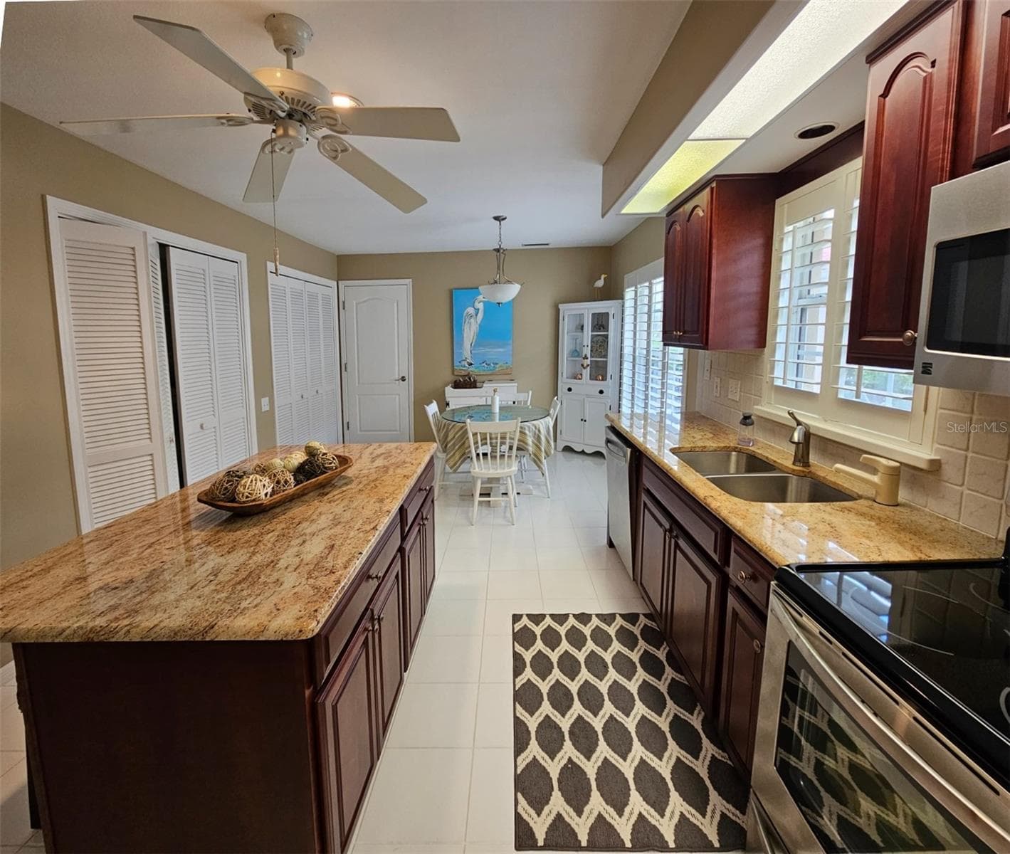 Large kitchen features granite counters, center island , wood cabinets, ample counter and closet storage. In the second closet is the washer and dryer. - 8351 CREEKVIEW LN, ENGLEWOOD