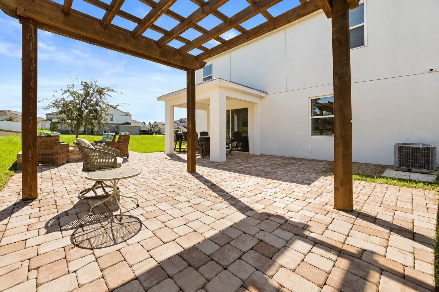 Extended paver patio with pergola, perfect for relaxing outdoors. - 7104 DILLY LAKE AVE, GROVELAND