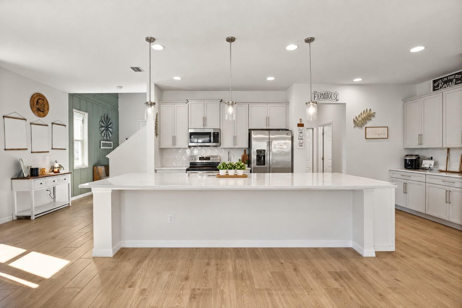 Bright, open-concept kitchen with quartz countertops and an oversized island. - 7104 DILLY LAKE AVE, GROVELAND