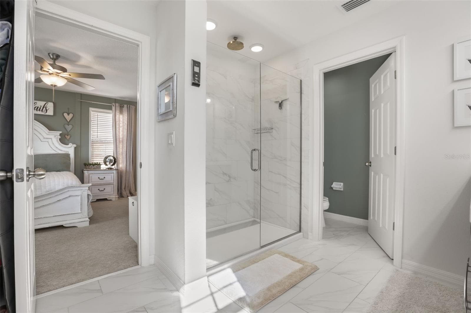 Primary bathroom featuring a large rainfall shower and smart shower controller. - 7104 DILLY LAKE AVE, GROVELAND