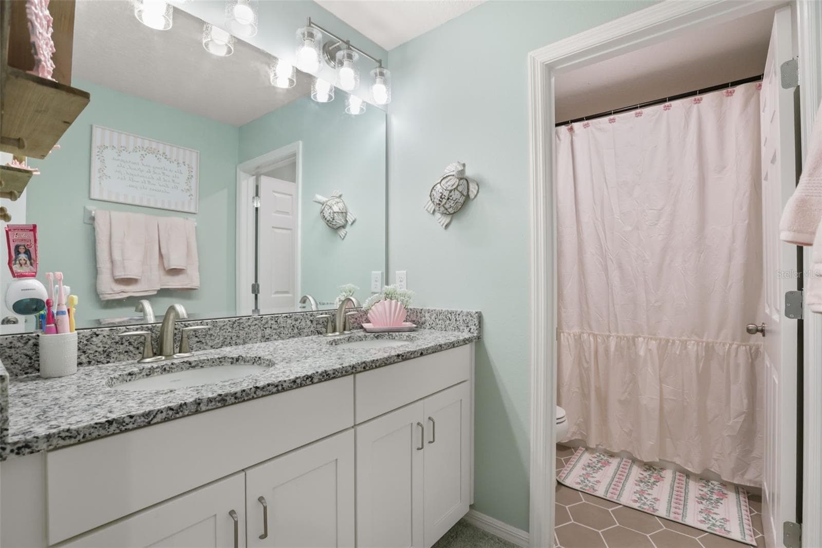 Secondary bathroom with stone countertops and a bathtub with shower. - 7104 DILLY LAKE AVE, GROVELAND