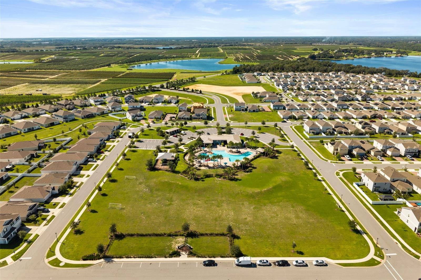 Aerial view of Trinity Lakes, showcasing the community pool, clubhouse, and surrounding neighborhood. - 7104 DILLY LAKE AVE, GROVELAND