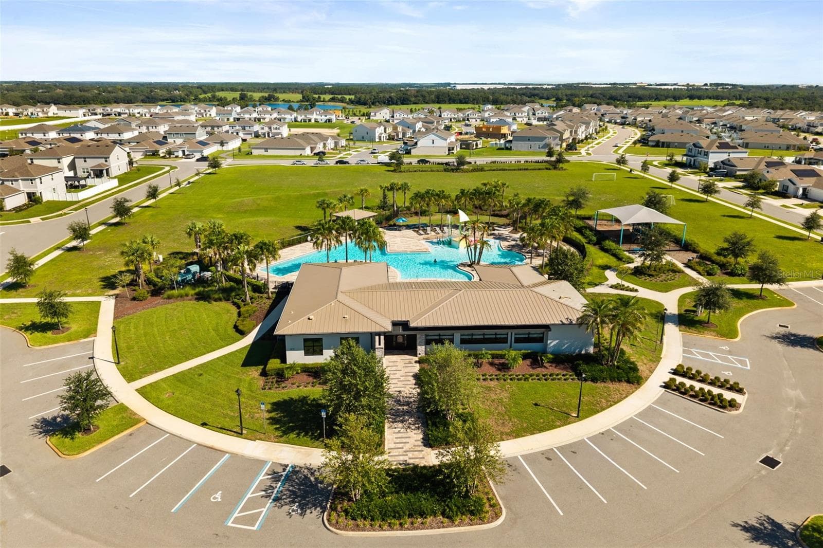 Aerial view of the Trinity Lakes clubhouse, community pool, and surrounding amenity area. - 7104 DILLY LAKE AVE, GROVELAND