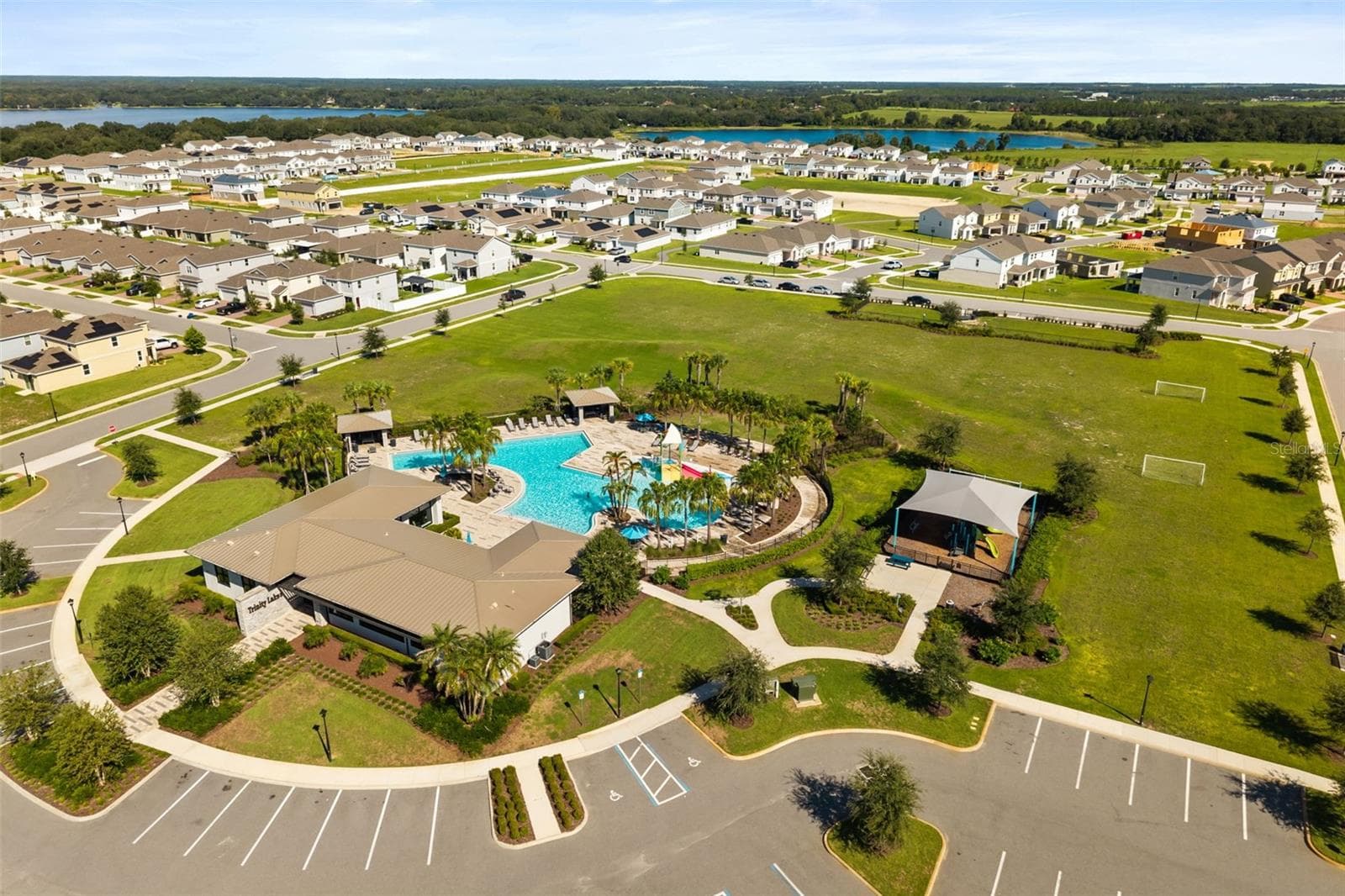 Another aerial view of the Trinity Lakes amenity center with the pool, clubhouse, and surrounding community. - 7104 DILLY LAKE AVE, GROVELAND