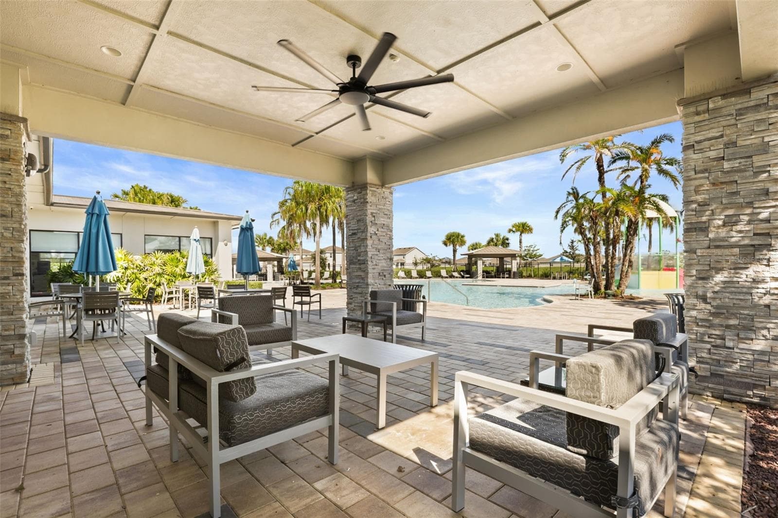 Another view of the covered outdoor lounge area with seating and easy access to the community pool. - 7104 DILLY LAKE AVE, GROVELAND