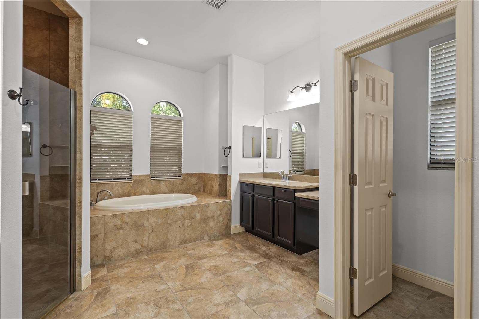 En suite primary bathroom with double sinks, walk in shower, and garden tub - 14834 MAN O WAR DR, ODESSA