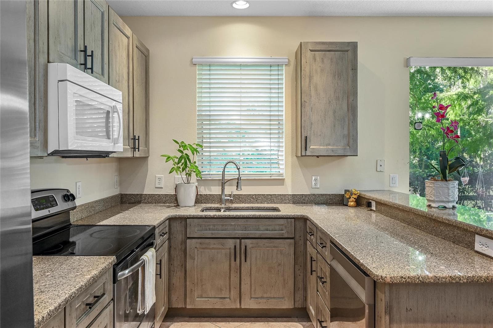 new kitchen with soft close cabinets and stone counters - 104 CANTERBURY BELL DR, OVIEDO