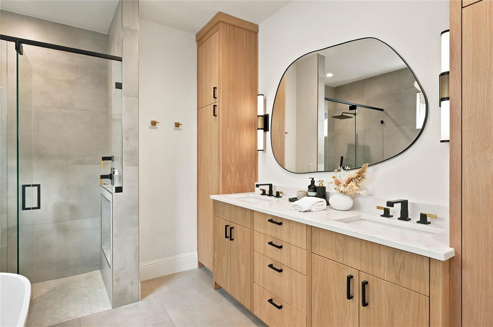 pairs warm wood cabinetry with clean contemporary finishes featuring a double vanity accented by mixed black and brass fixtures. A statement mirror & lighting add an artful touch to the serene, sophisticated space. - 1707 ASHER LN, ORLANDO