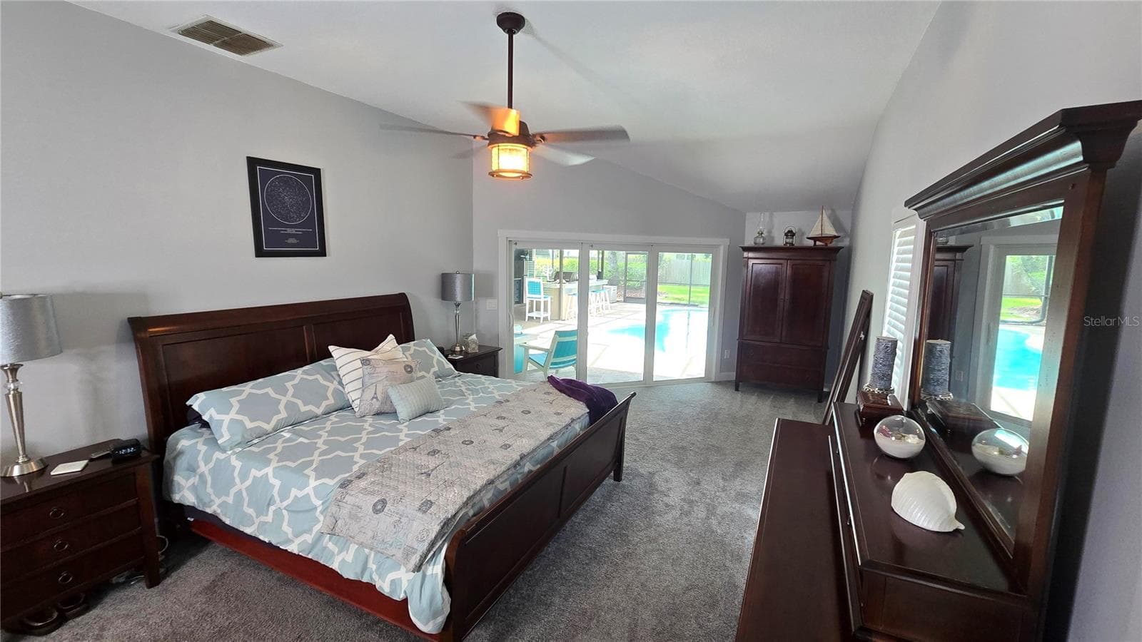 This primary suite bedroom has its own personal access through the sliding glass doors to enter the pool area. Size of bedroom is approximately 26 x 13 not including the 2 walk-in closets. - 9991 WINDTREE BLVD, SEMINOLE