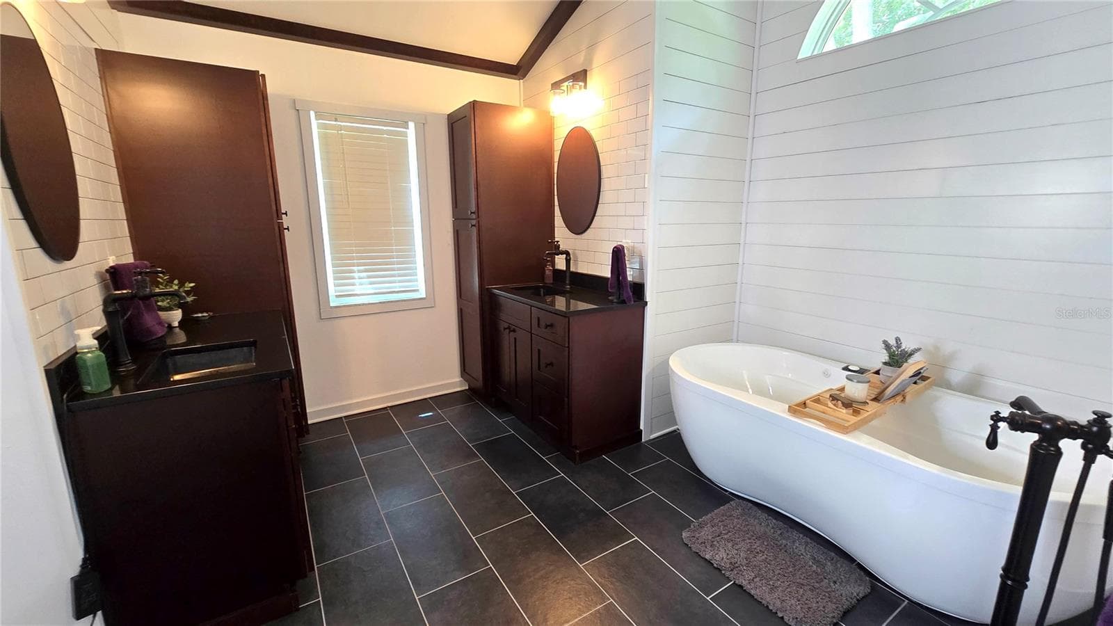 Primary Bathroom with 2 cabinets/vanity.  Don't overlook this adorable tub to relax in after a hard day at work. - 9991 WINDTREE BLVD, SEMINOLE