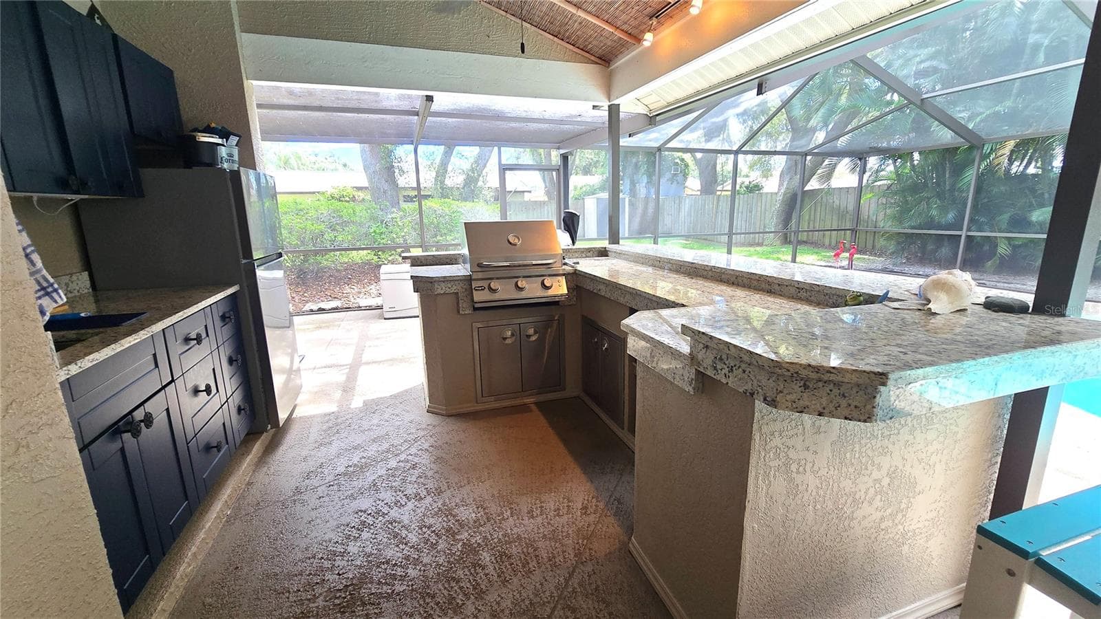 Like to party?  Host all the parties here with this outdoor kitchen area with a built in bar-b-que, cabinets and sit up bar area. - 9991 WINDTREE BLVD, SEMINOLE