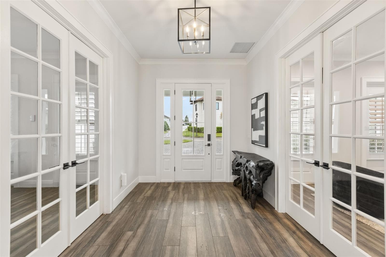 TWO PRIVATE ROOMS OFF THE FOYER Looking toward the front entry, the foyer is framed by double French doors leading to a dedicated executive office on one side and a flexible en suite guest or au pair room on the other - 907 CELADON ST, WINTER GARDEN