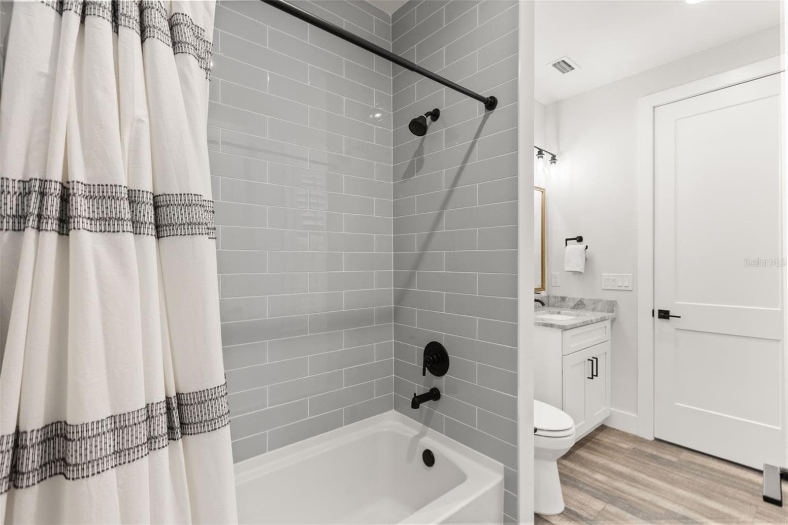 EN SUITE FULL BATH | DUAL ACCESSFull bath serving the en suite room off the foyer, with dual access from the mudroom/back entrance for added flexibility. - 907 CELADON ST, WINTER GARDEN