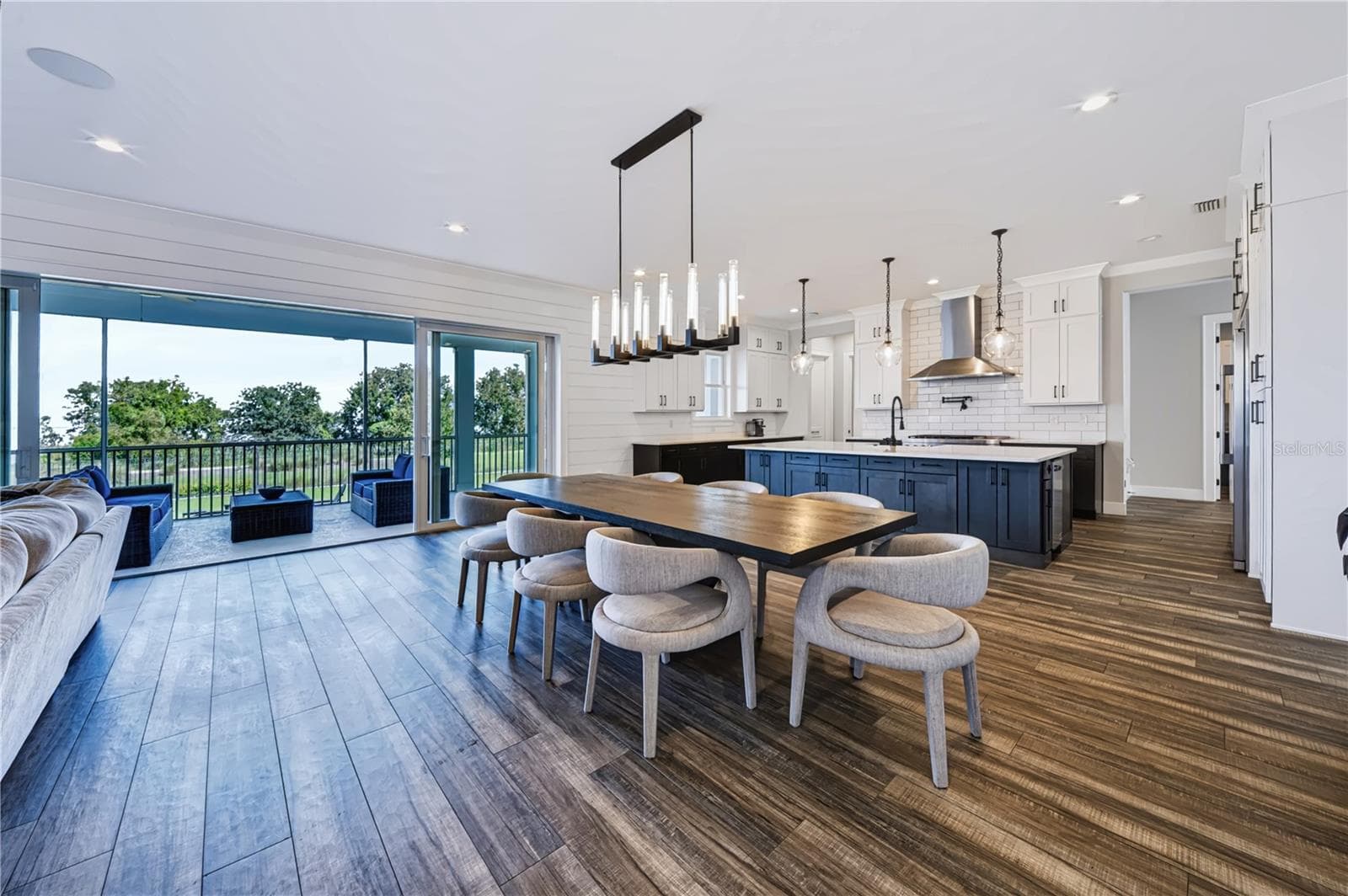 GOURMET KITCHENA spacious gourmet kitchen with a large center island and generous seating opens directly to the living and dining areas, with expansive sliders beyond.sliding doors opening to an expansive porch over conservation and Lake Apopka. - 907 CELADON ST, WINTER GARDEN