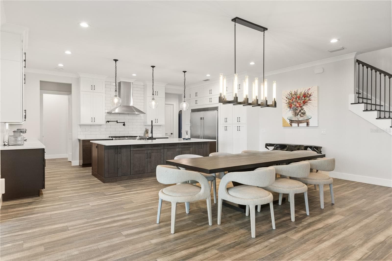 EXPANSIVE KITCHEN + DININGAn oversized center island anchors the gourmet kitchen, with abundant cabinetry and an open dining area designed to accommodate a large table and effortless entertaining. - 907 CELADON ST, WINTER GARDEN
