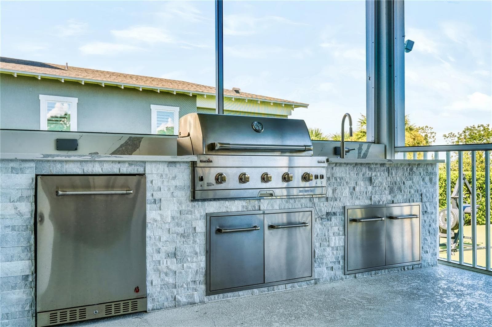 OUTDOOR KITCHENThe screened porch features a built-in outdoor kitchen with stainless grill, sink, under-counter refrigeration and generous storage—designed for easy al fresco dining and year-round entertaining. - 907 CELADON ST, WINTER GARDEN