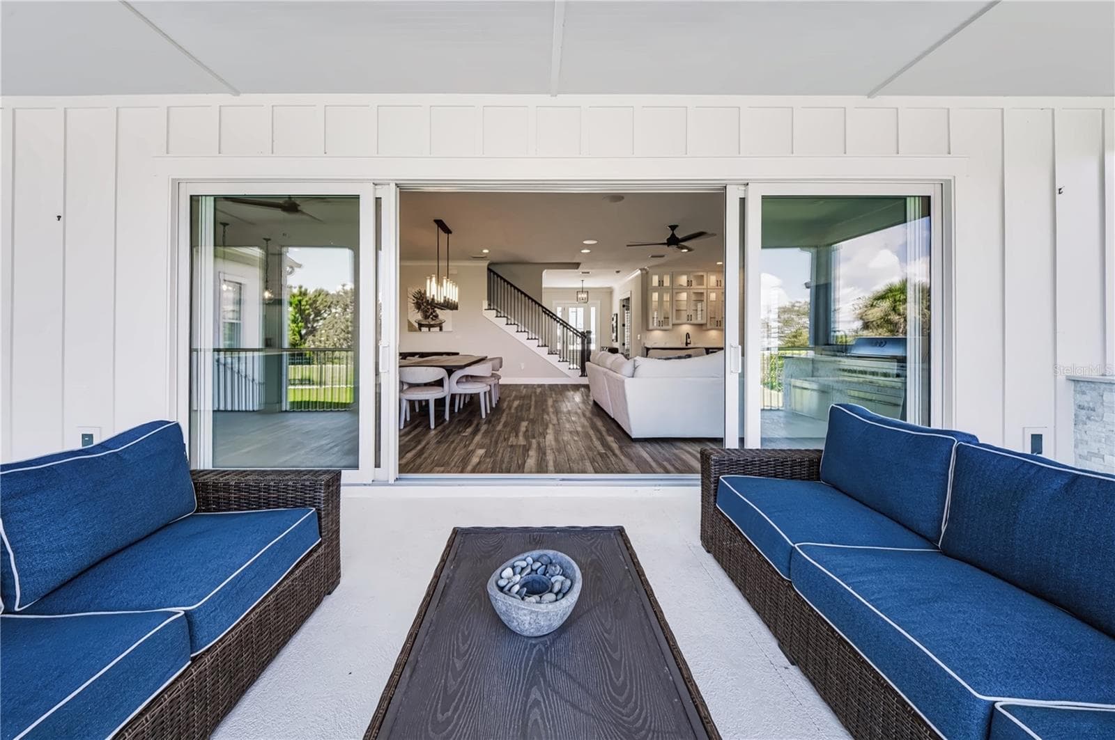EXPANSIVE SLIDING GLASS DOORSExpansive sliders open the main living and dining areas directly to the screened porch, creating an uninterrupted connection between the interior and outdoor entertaining spaces. - 907 CELADON ST, WINTER GARDEN