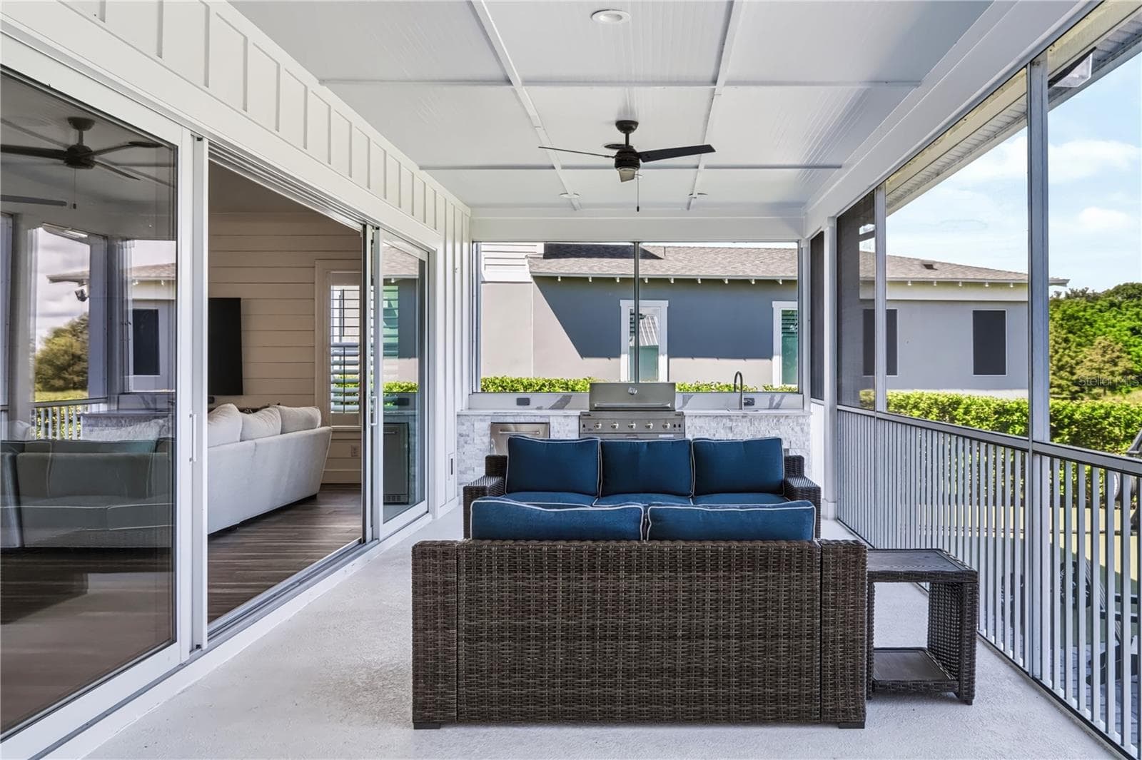 39' × 13' SCREENED PORCHNearly 40 feet of covered, screened space provides a substantial setting for outdoor seating and entertaining, with the built-in outdoor kitchen at the far end. - 907 CELADON ST, WINTER GARDEN