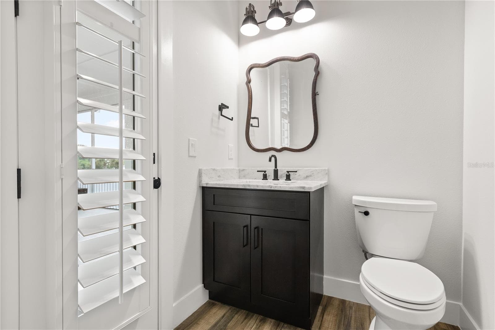 1/2 BATH + SCREENED PORCH ACCESSConveniently located just off the kitchen, this 1/2 bath provides direct access to the screened porch and sits just before the private primary wing - 907 CELADON ST, WINTER GARDEN