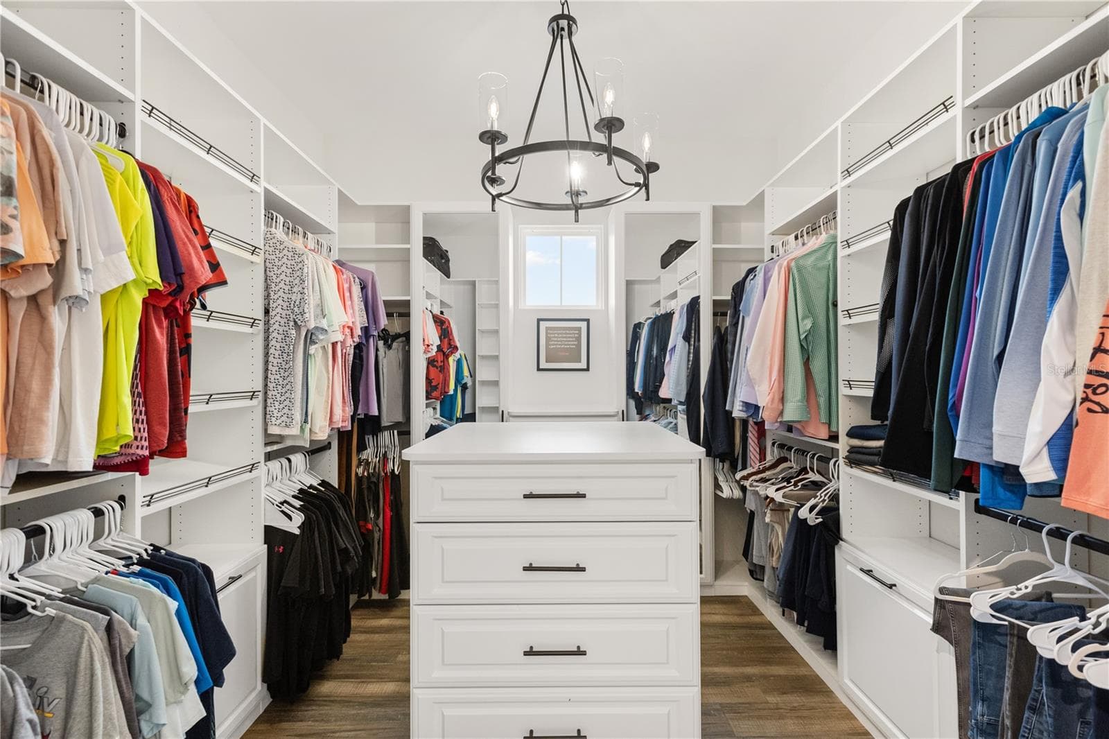 OVERSIZED WALK-IN CLOSETThe primary suite includes an oversized walk-in closet with extensive built-in storage, a center island with drawers and abundant hanging space. - 907 CELADON ST, WINTER GARDEN