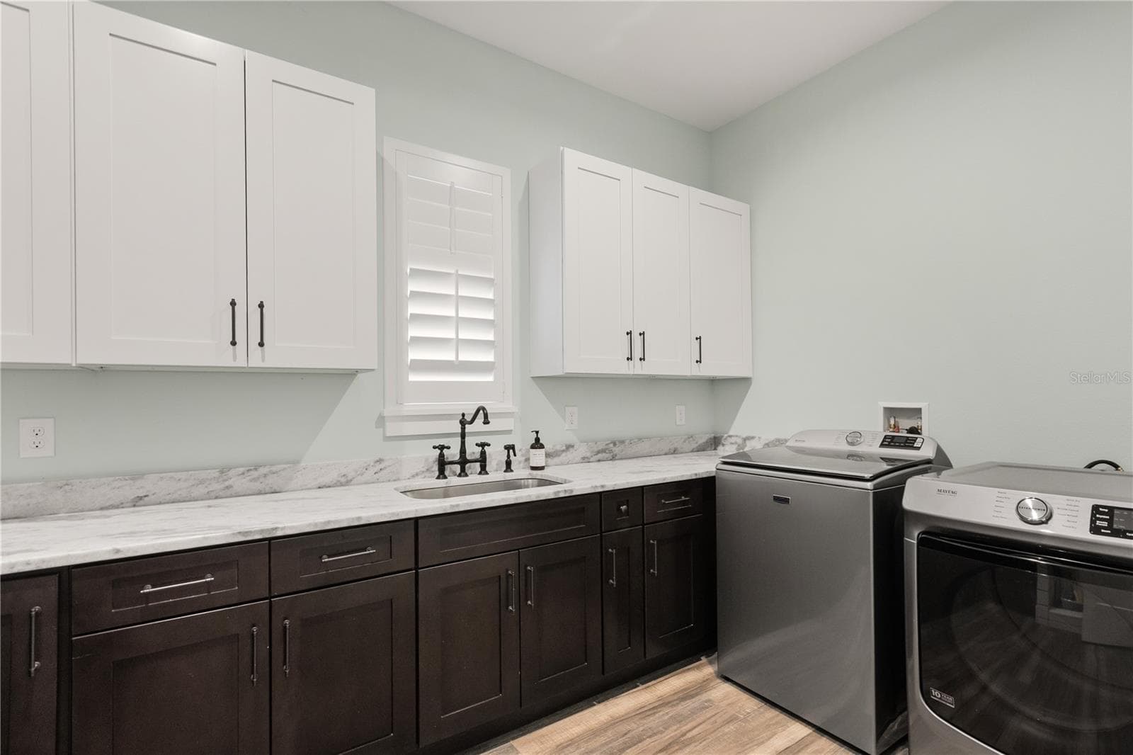 DEDICATED LAUNDRY ROOMThe dedicated laundry room features extensive cabinetry, generous counter space and a utility sink, with the mudroom and kitchen nearby. - 907 CELADON ST, WINTER GARDEN