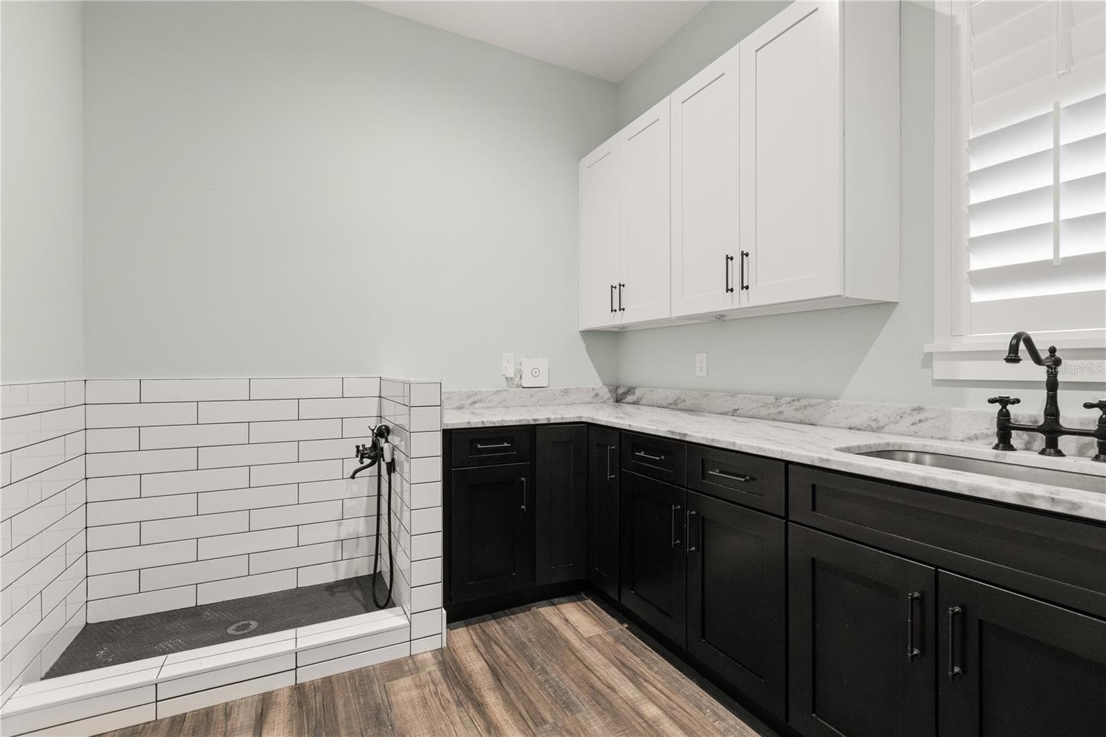 BUILT-IN DOG WASH STATIONA built-in dog wash station adds another practical feature to the laundry room, surrounded by abundant cabinetry and counter space. - 907 CELADON ST, WINTER GARDEN