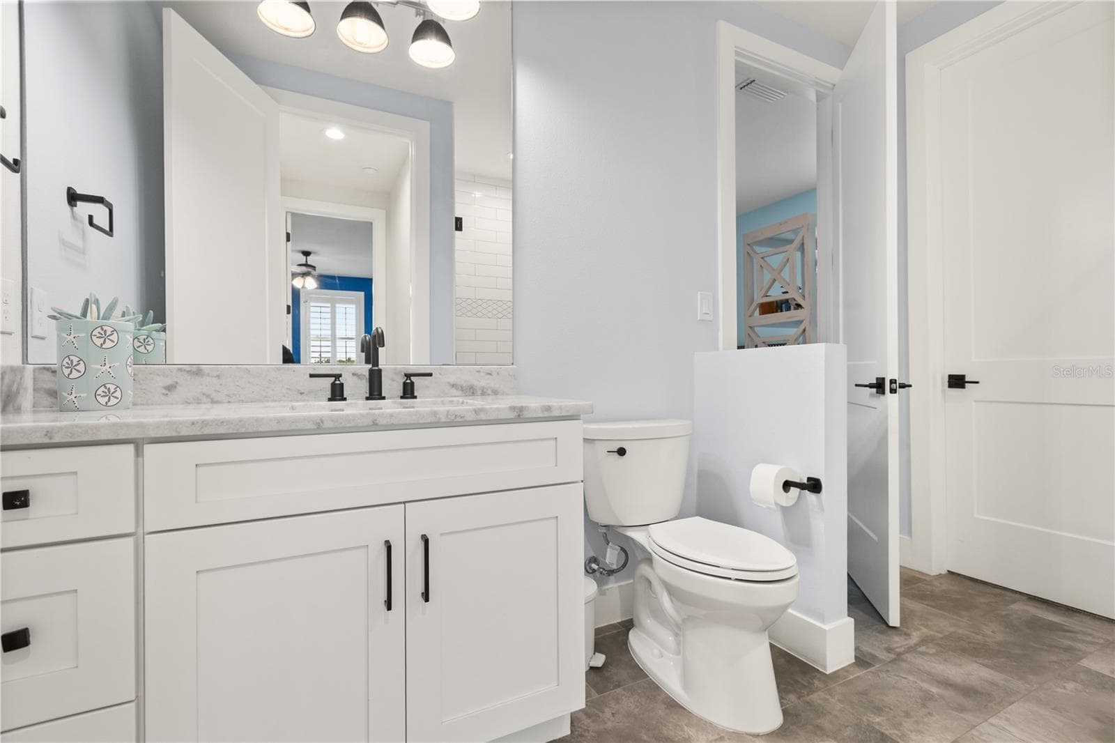 EN SUITE FULL BATHA private full bath serves the adjoining second-floor bedroom, with a separate hallway entrance providing additional access from the loft level. - 907 CELADON ST, WINTER GARDEN
