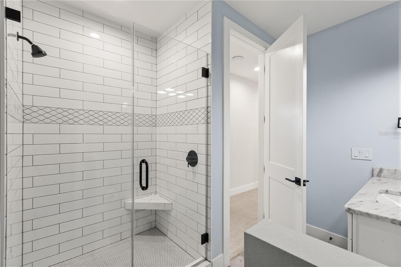 FULL-SIZE WALK-IN SHOWERThe en suite bath features a full-size glass-enclosed walk-in shower, with direct access from the adjoining second-floor bedroom. - 907 CELADON ST, WINTER GARDEN