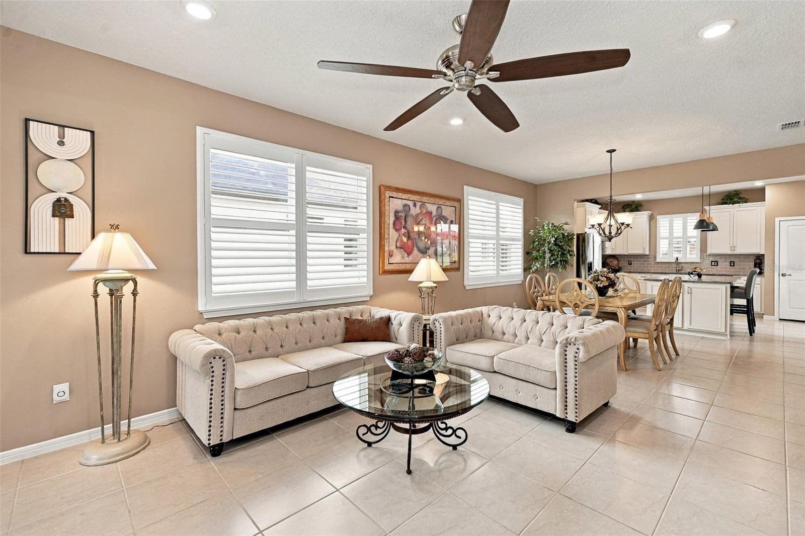 Living Rm area with ceiling fan & double window w/plantation shutters - 5995 SW 93RD CIR, OCALA