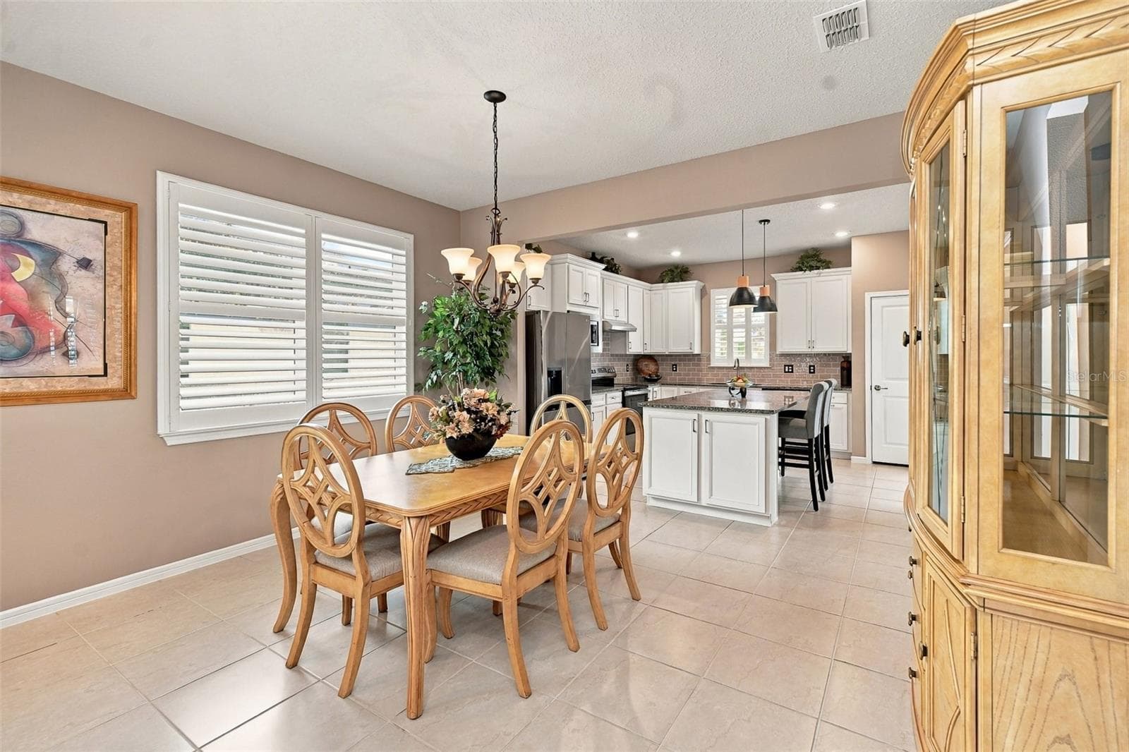 Dining area with double window w/ plantation shutters & chandelier - 5995 SW 93RD CIR, OCALA