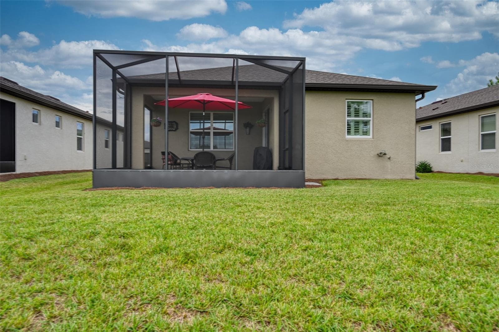 Rear view of home & screened lanai w/cage - 5995 SW 93RD CIR, OCALA