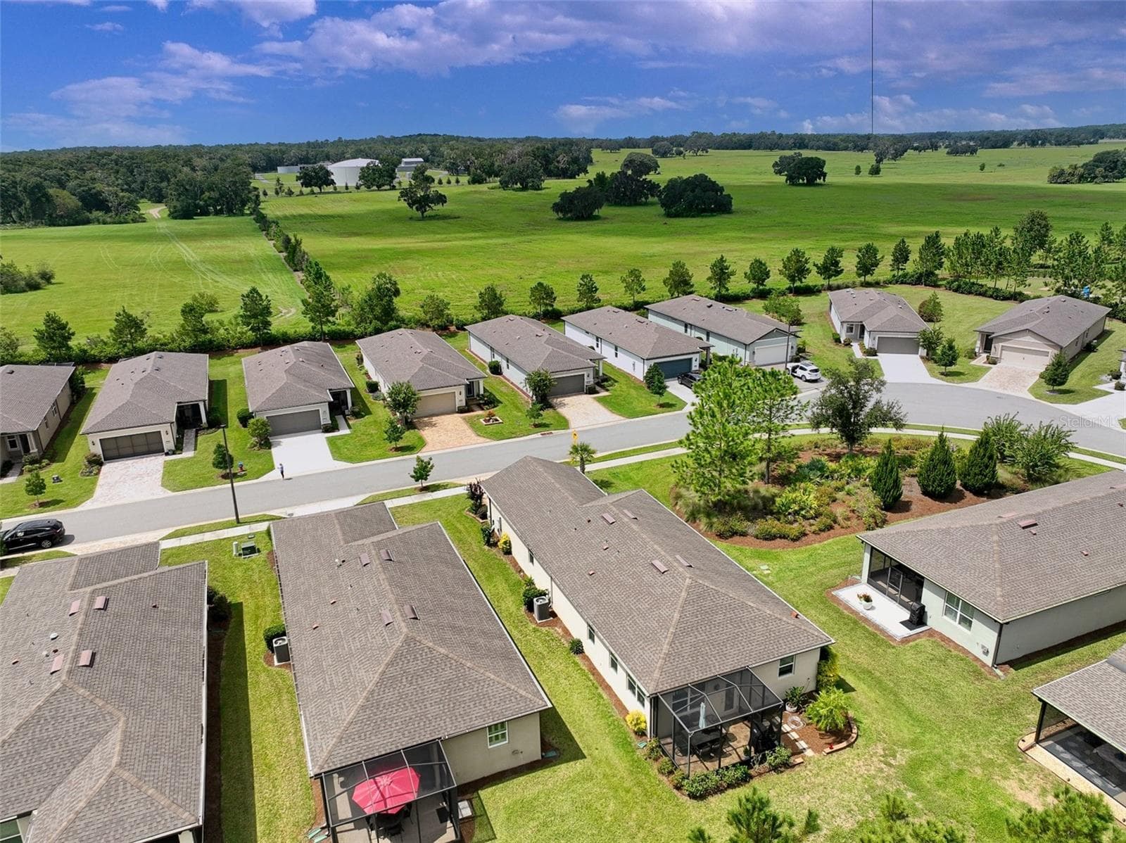 Aerial view of surrounding area from rear of home (red umbrella visible in screened cage). - 5995 SW 93RD CIR, OCALA