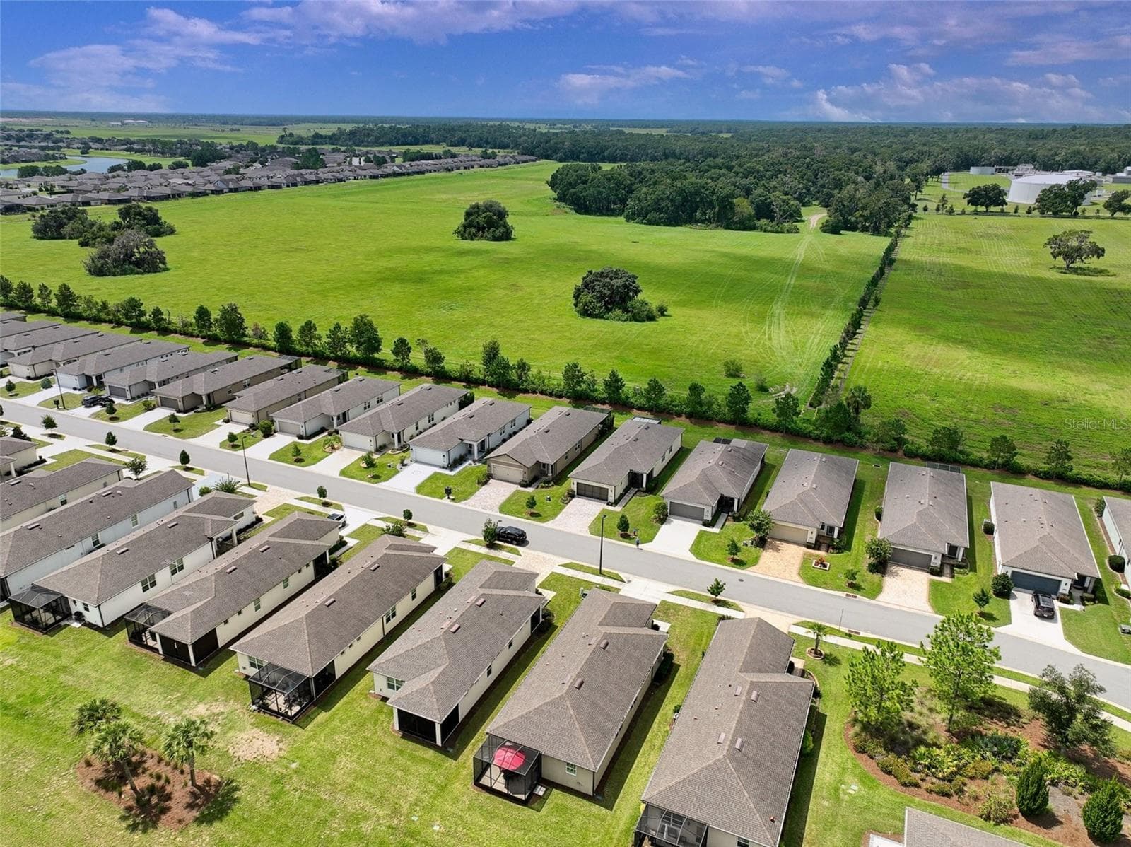 Aerial view of surrounding area from rear of home (red umbrella visible in screened cage). - 5995 SW 93RD CIR, OCALA