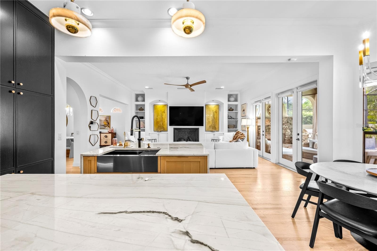 Veined stone island countertop with view to the family room and French doors beyond. - 1921 FLORESTA VIEW DR, TAMPA