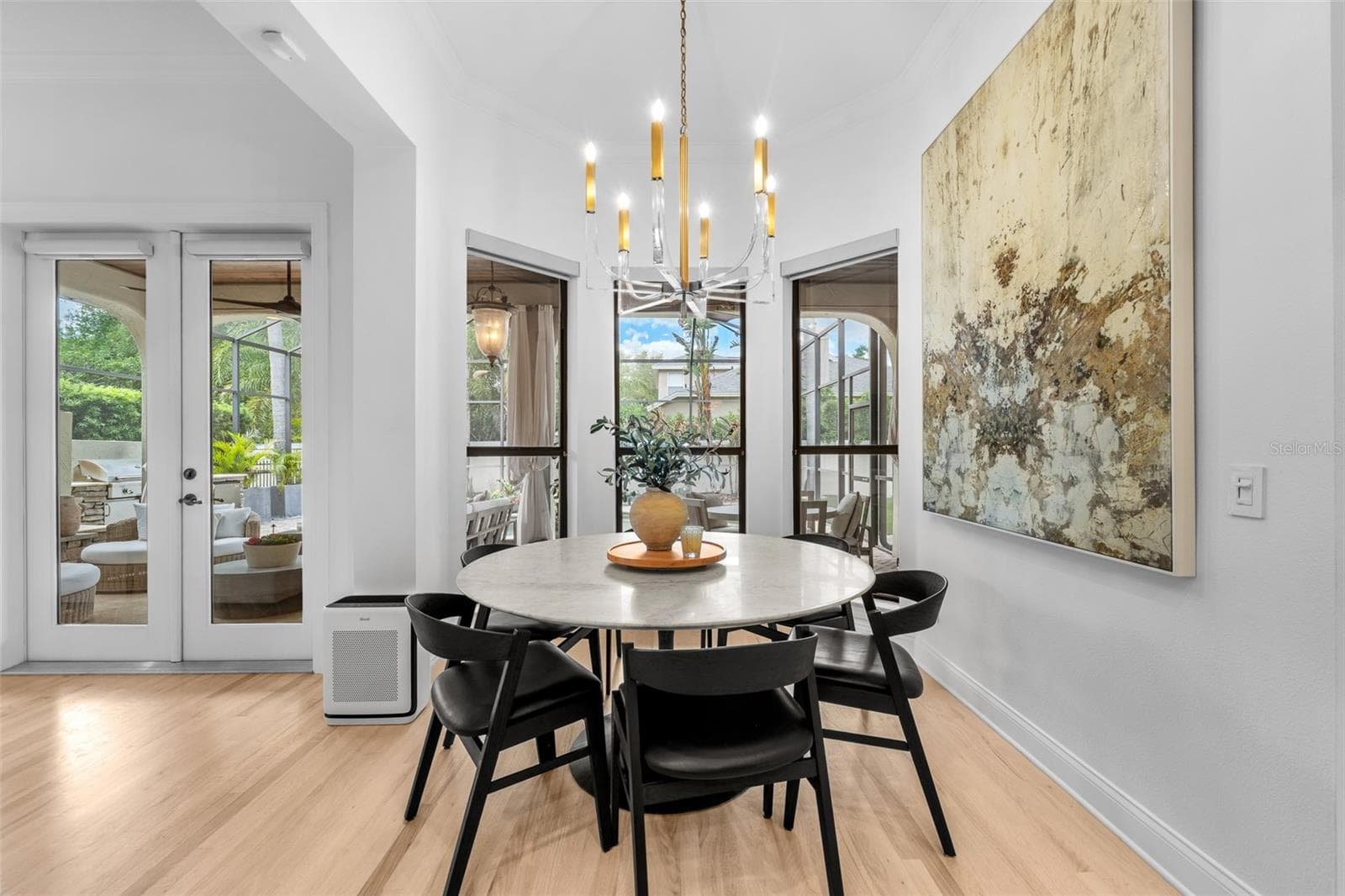 Casual dining area with French doors to the lanai, candle-style chandelier, and light wood flooring. - 1921 FLORESTA VIEW DR, TAMPA