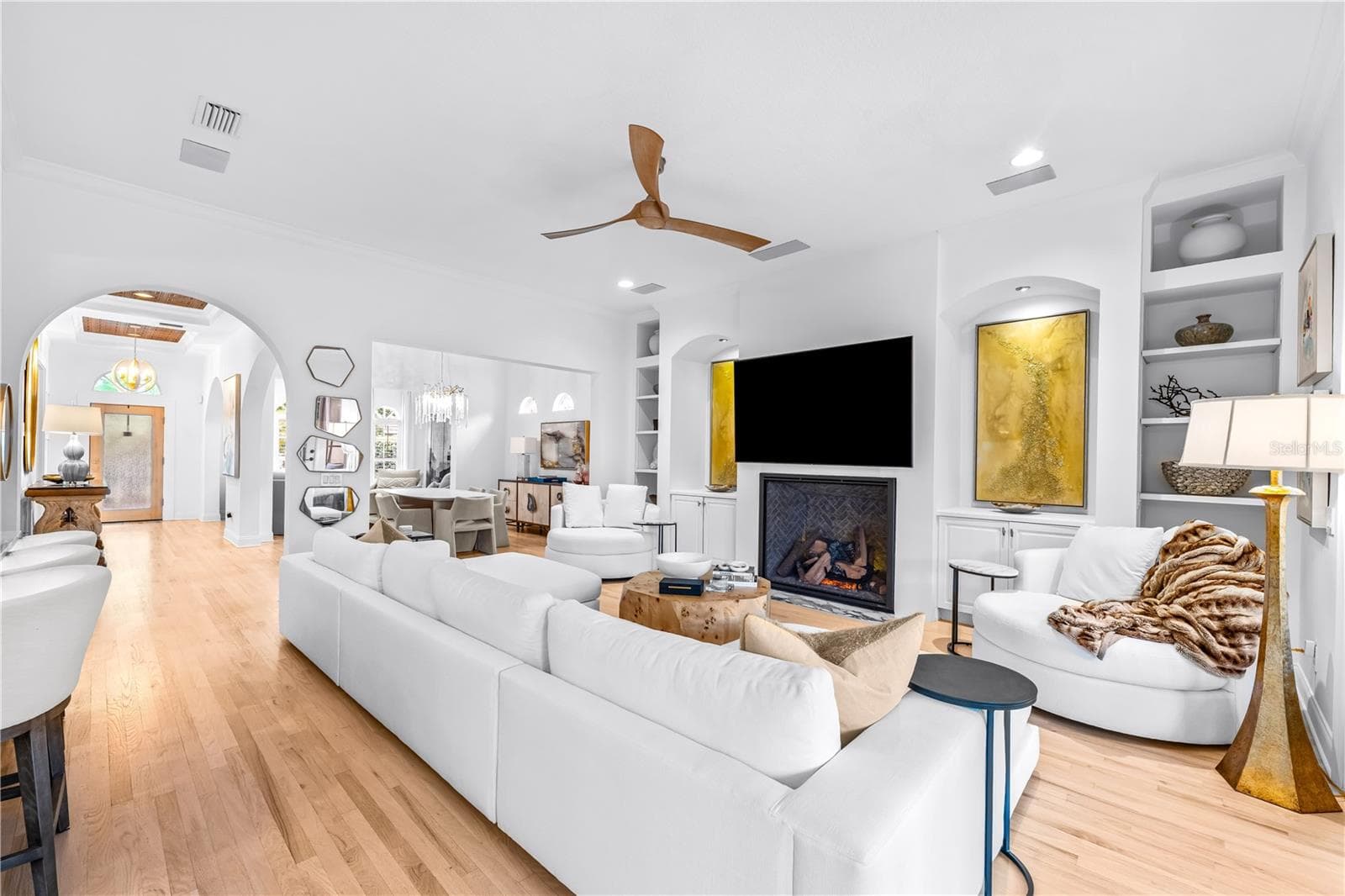 Fireplace with built-in shelving, ceiling fan, and French doors to the covered lanai. - 1921 FLORESTA VIEW DR, TAMPA