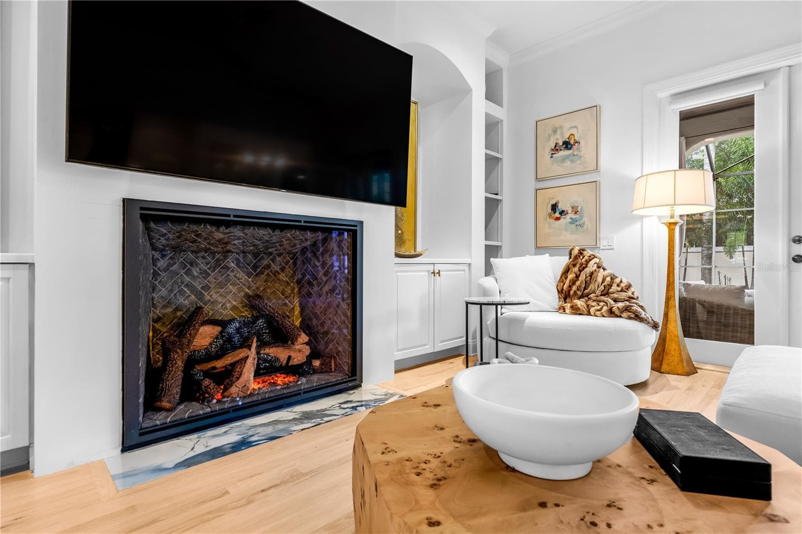 Fireplace with mounted TV and flanking built-in shelving. - 1921 FLORESTA VIEW DR, TAMPA