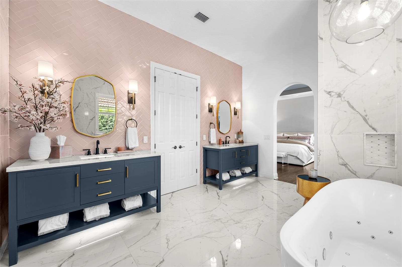 Primary Bathroom - Dual navy vanities, freestanding soaking tub, and arched opening to the bedroom. - 1921 FLORESTA VIEW DR, TAMPA