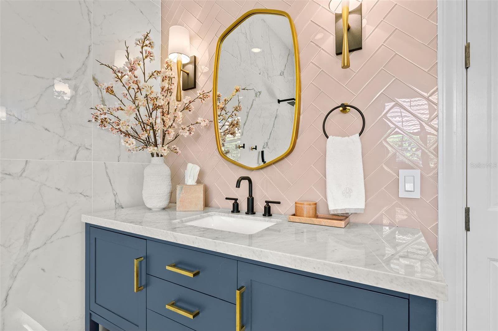 Vanity detail with brass-framed mirror, sconces, and matte black faucet. - 1921 FLORESTA VIEW DR, TAMPA